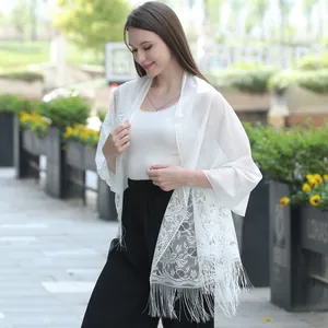 Detailed view of white floral lace bridal shawl wrap featuring elegant patterns and fringes
