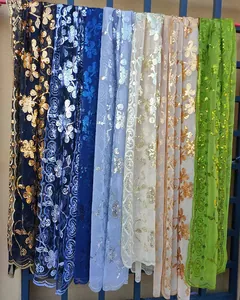 Detail view showing variety of colorful sequined floral lace shawls for weddings