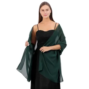 Châle en mousseline vert foncé élégamment associé à une robe de soirée noire.