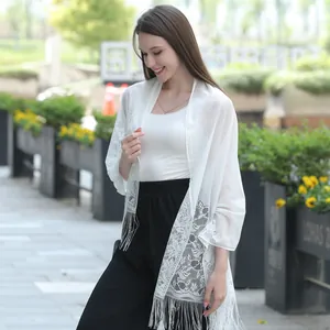 Elegant white floral lace shawl with fringe worn in an outdoor casual lifestyle setting