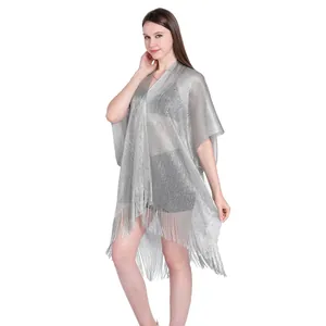 Close-up of shimmering silver shawl with tassels worn as a bikini cover-up
