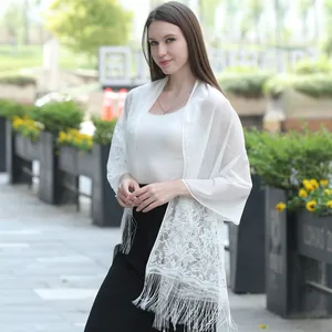 Elegant white floral lace shawl with decorative fringe detail on female model outdoors
