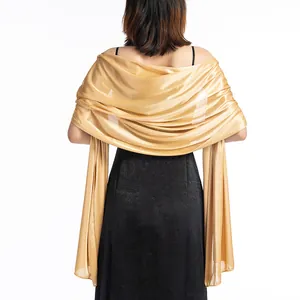 Back view of an elegant gold satin evening shawl draped over a formal black dress