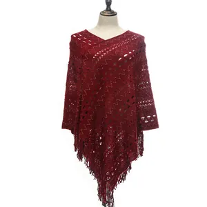 Detailed view of the dark red knitted hollow-out poncho with tassel hem decoration