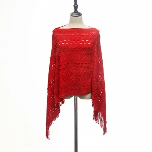 Red hollow-out crochet poncho with elegant tassel hem displayed on a mannequin stand