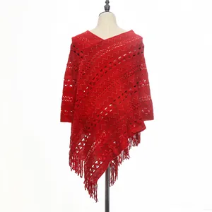 Vibrant red bohemian style knit hollow-out poncho with fringe tassels displayed on mannequin