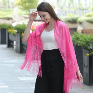 Detail view of sweet pink lace shawl with delicate floral patterns and tassel hem.