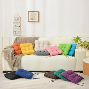 Close-up detail of multi-colored thickened fabric seat cushions with ties on a white sofa