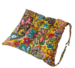 Detail view of bohemian floral pattern and secure corner ties on yellow seat cushion