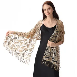Detail of the intricate golden paisley lace shawl with sparkling sequined fringe accents.