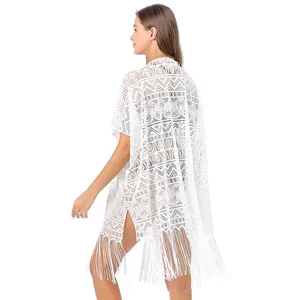Detail achteraanzicht van witte kant strand cover-up met geometrisch patroon en kwastjes