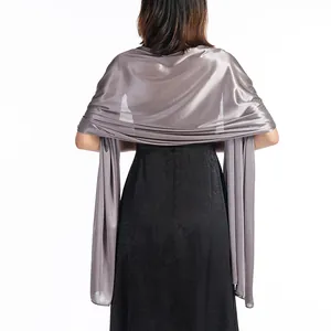Elegant silver satin evening shawl wrap draped over a black formal dress, back view