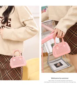 Close-up detail of mini pink jelly shell bag with gold chain strap carried by model