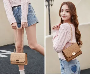Elegant quilted handbag with gold chain strap carried by female model in street style.