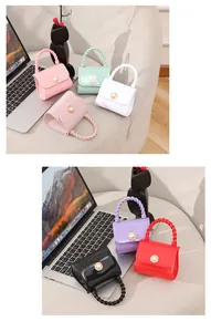 Multiple colors of mini jelly handbags featuring pearl buckle and twisted handle design.