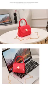 Close-up of a mini red jelly handbag with pearl buckle on a laptop keyboard