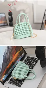 Detail view of a mint green beaded mini jelly bag displayed on a laptop keyboard