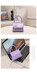 Detail view of a purple mini jelly handbag with pearl accent and gold chain strap