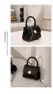 Glossy black mini jelly handbag featuring elegant pearl closure and crocodile texture detail
