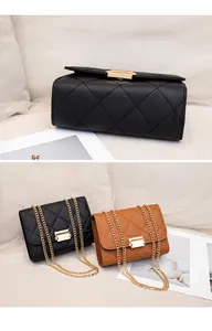 Detail view of black and tan quilted bags with golden chain straps and locks.