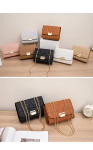 Close-up of triangle quilted flap bags with golden chain straps and metal locks.