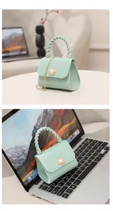 Close-up of mint green jelly mini bag with pearl button and gold chain strap