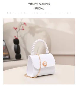 Close-up view of a white mini jelly handbag featuring a pearl buckle and gold chain strap