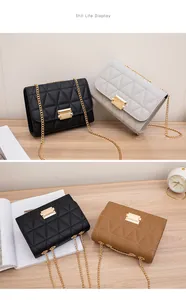 Various colors of triangular embroidered chain crossbody bags displayed on a wooden table setup