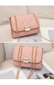 Macro view of pink quilted leather crossbody bag featuring gold chain and lock details