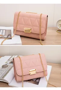 Close-up detail of stylish pink quilted small square bag with gold chain strap and lock