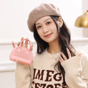 Trendy pink mini jelly shell handbag with pearl texture being held by an Asian model