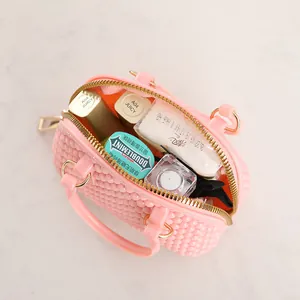 Stylish pink jelly mini shell handbag showing internal capacity with cosmetics