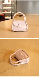 Vues détaillées du sac à main rose en gelée avec sa chaîne dorée et sa poignée ronde.
