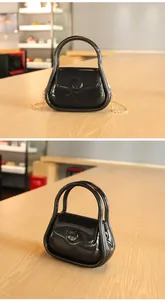 Vue détaillée d'un petit sac en gelée noir brillant avec une bandoulière dorée