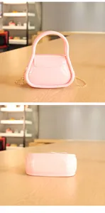 Vue détaillée d'un sac en gelée rose bonbon avec une chaîne dorée et une poignée.