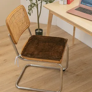 Plush brown chair cushion on a rattan back chair in a warm home office setting