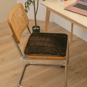 Dark brown plush seat cushion on a wooden chair in a cozy home office setting