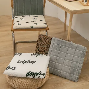 Close-up of various plush heated chair cushions with star and leopard patterns in a home setting