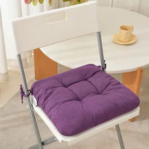 Purple thickened fabric chair cushion with straps on a white chair in home setting