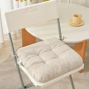 Detailed view of a thick beige linen fabric chair cushion with secure tie straps