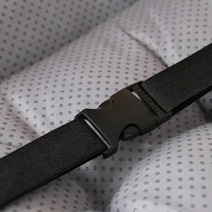 Close-up detail of the adjustable buckle and elastic strap on a grey bean velvet cushion