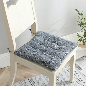 Detalle de un cojín de silla grueso en algodón y lino con patrón de olas azules clásicas.