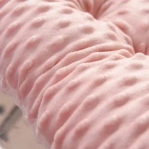 Macro close-up of soft pink minky dot plush fabric texture on a thickened seat cushion