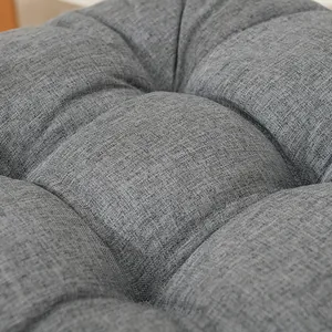 Macro detail view showing the texture and tufted design of a thick grey fabric chair cushion