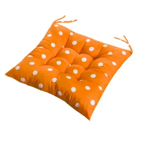 Soft orange polka dot chair pad with tufted design and secure back ties for office use.