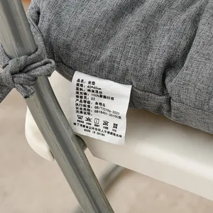 Detail view of the washing label on a gray thickened fabric seat cushion with ties