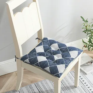 Detalle de un cojín de silla de algodón y lino con patrón geométrico azul y blanco con lazos
