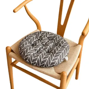 Cojín redondo grueso para silla con patrón de espiga gris en una silla de madera.