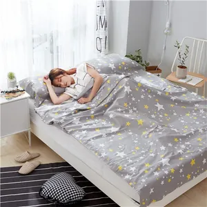 Portable cotton travel sleeping bag liner with star pattern shown in a cozy bedroom scene