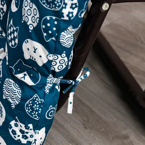 Close-up detail of navy blue thick chair cushion with cute white cat patterns and ties